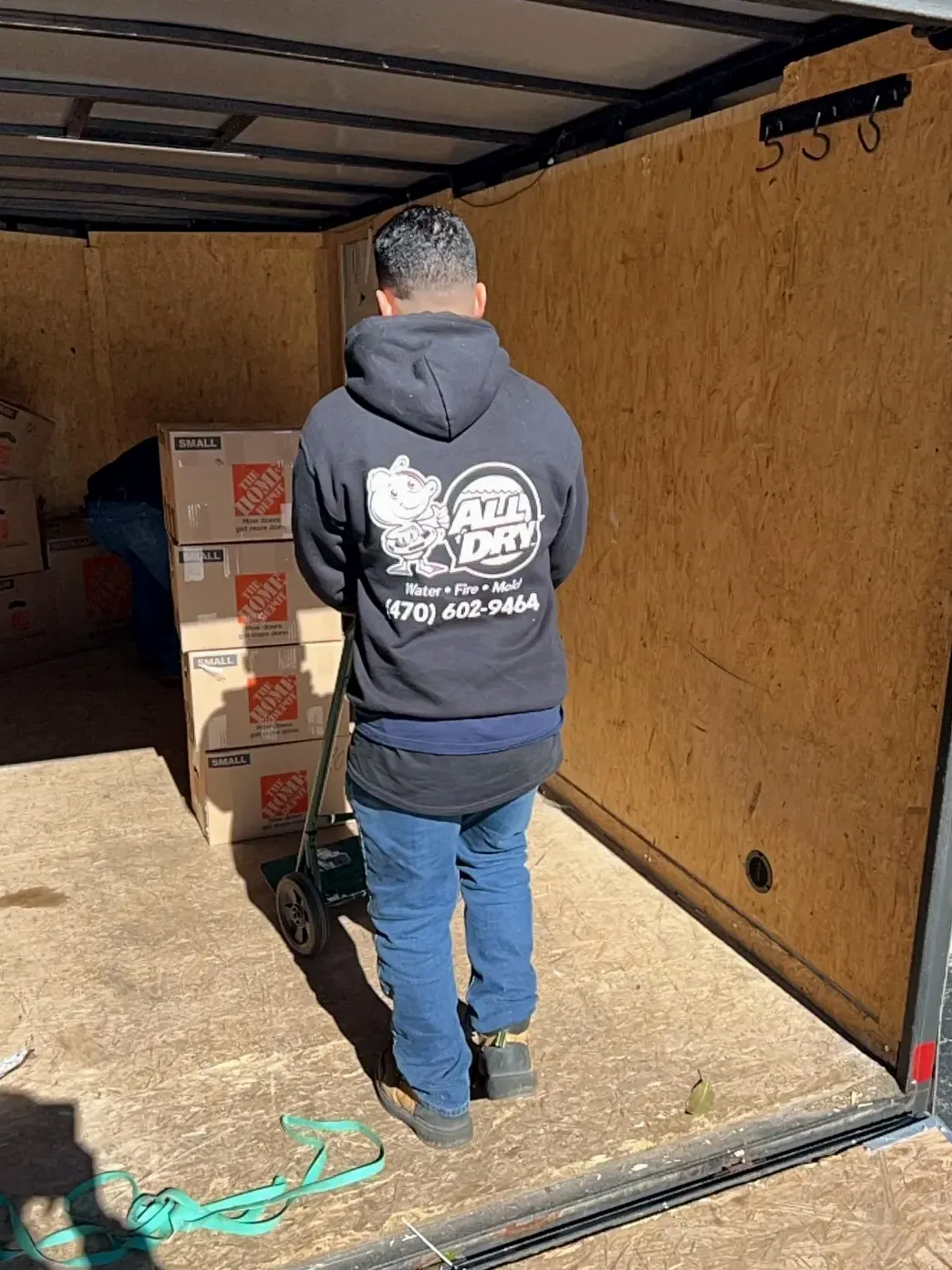 All Dry pack-out technician loading boxed contents into a trailer