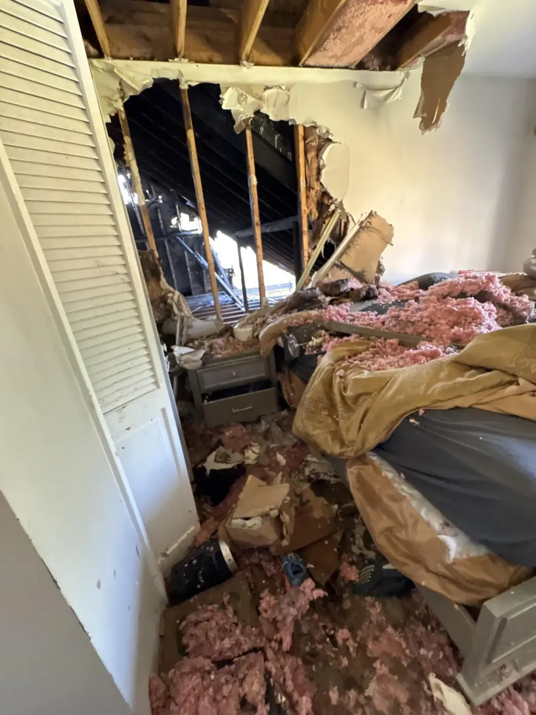 Collapsed ceiling and insulation in a bedroom after a fire in metro Atlanta