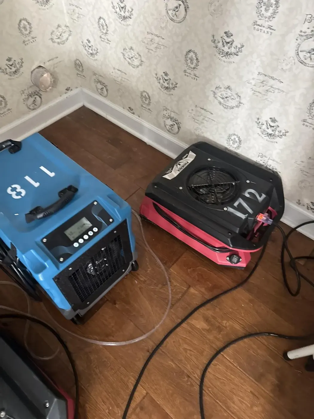 Dehumidifier and air mover set up along a wet wall in Suwanee, GA