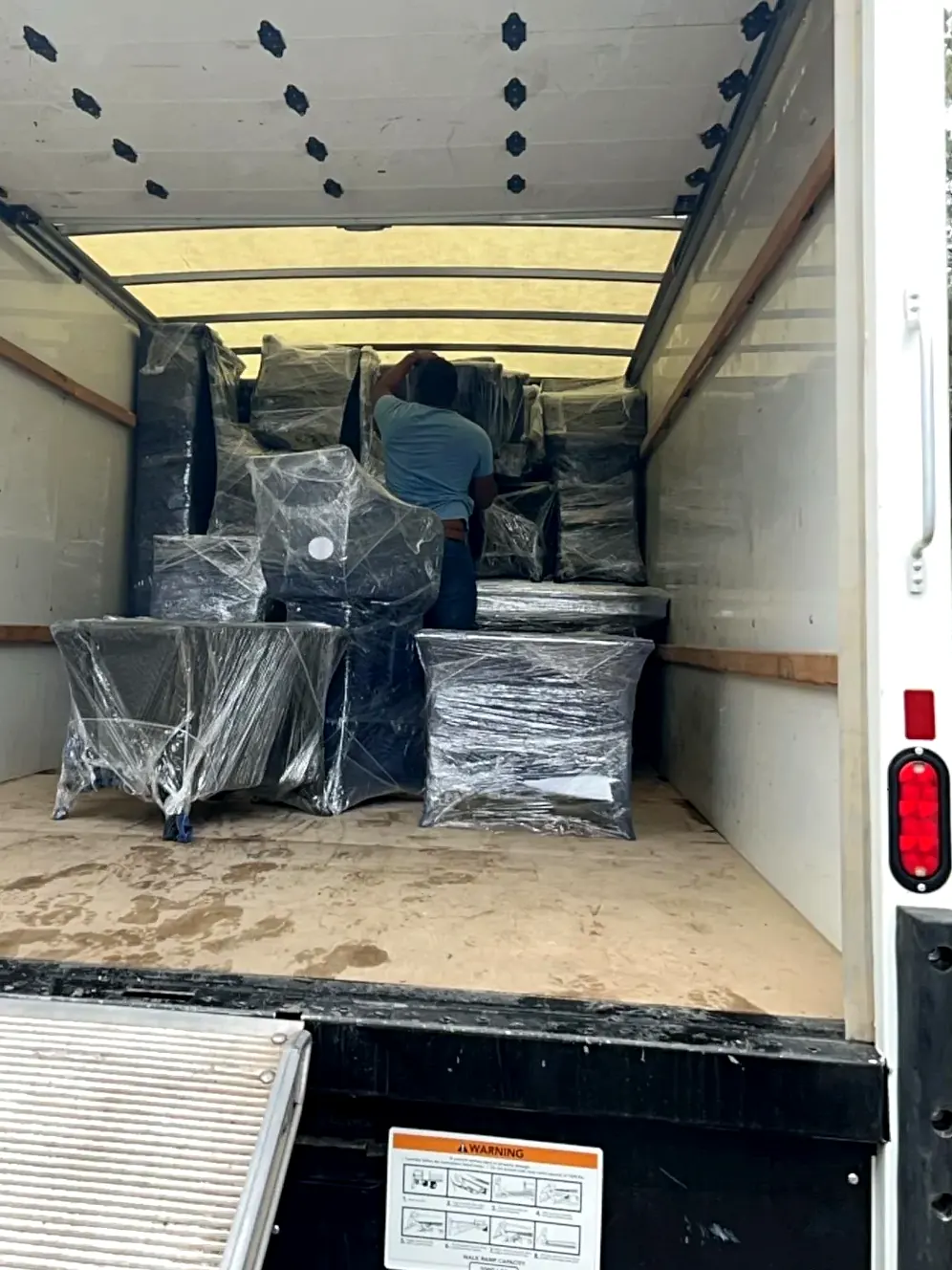 Shrink-wrapped furniture protected inside a truck during contents pack-out